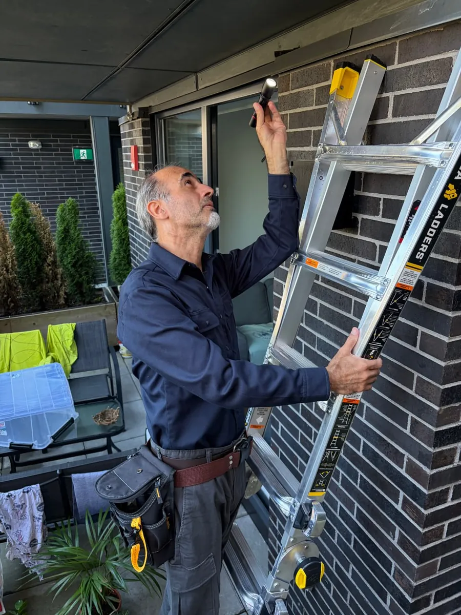 Licensed BC home inspector Vahid Alikhanzadeh examining an exterior building component.